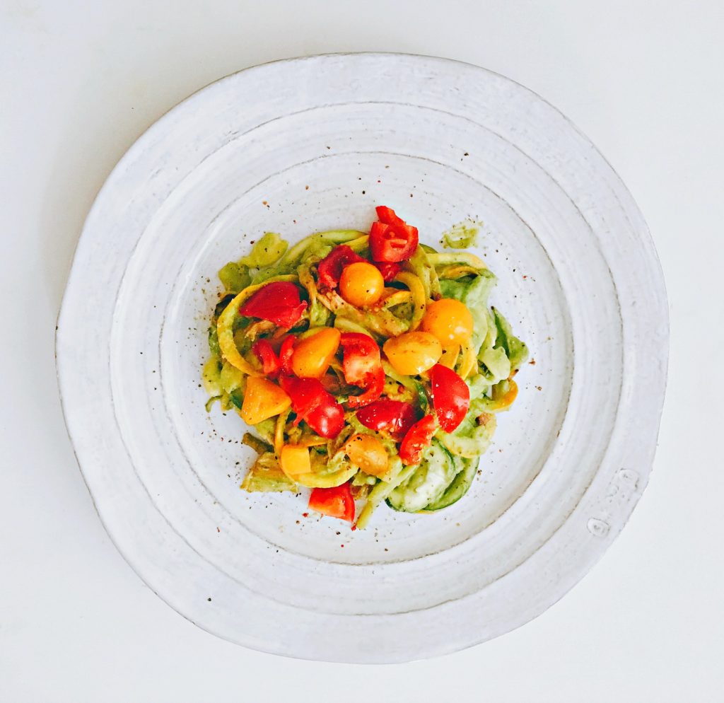 Zucchini Noodles dressed with avocado sauce and cherry tomatoes, gluten-free and grain-free for paleo and vegan diets